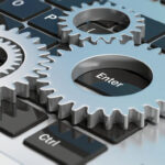 Silver_chrome_gears_on_a_computer_keyboard._3d_illustration