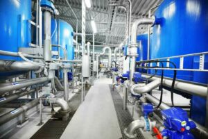 Large_blue_tanks_in_a_industrial_city_water_treatment_boiler_room._Wide_angle_perspective._Special_equipment,_technology,_drinking_water_supply,_chemical_modifications,_environmental_conservation