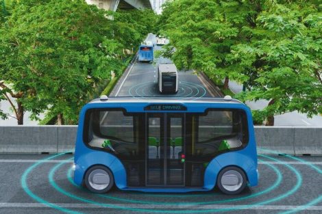 Autonomous_electric_shuttle_bus_self_driving_across_city_green_road,_Smart_vehicle_concept