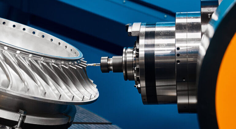 Producing_turbine_wheel_part_with_five-axis_lathe_machine_at_production_plant_close_view._Work_of_robotized_equipment._Industry_and_technology