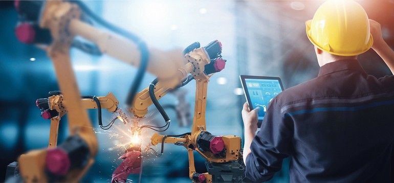 Engineer_check_and_control_welding_robotics_automatic_arms_machine_in_intelligent_factory_automotive_industrial_with_monitoring_system_software._Digital_manufacturing_operation._Industry_4.0
