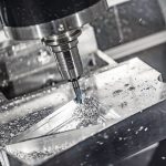 Metalworking_CNC_milling_machine._Cutting_metal_modern_processing_technology._Small_depth_of_field._Warning_-_authentic_shooting_in_challenging_conditions._A_little_bit_grain_and_maybe_blurred.
