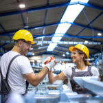 Factory_workers_handshaking_each_other_at_production_line.