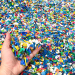 Hand_holding_Bottle_flake,PET_bottle_flake,Plastic_bottle_crushed,Small_pieces_of_cut_colorful_plastic_bottles