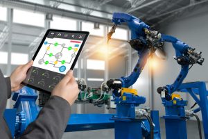 Engineer_hand_using_tablet,_heavy_automation_robot_arm_machine_in_smart_factory_industrial_with_tablet_real_time_process_control_monitoring_system_application._Industry_4th_iot_concept.