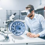 Factory_Chief_Engineer_Wearing_VR_Headset_Designs_Engine_Turbine_on_the_Holographic_Projection_Table.__Futuristic_Design_of_Virtual_Mixed_Reality_Application.