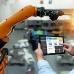 Engineer_hand_using_tablet,_heavy_automation_robot_arm_machine_in_smart_factory_industrial_with_tablet_real_time_monitoring_system_application._Industry_4th_iot_concept.