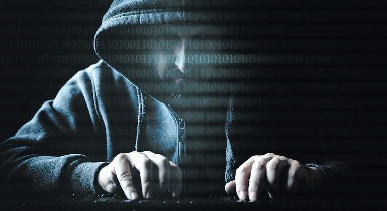 Hacker_an_Tastatur_mit_Binärcode,_Spionage_und_Cyberkriminalität,_Darknet_und_Sicherheit