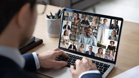 Businessman_talking_to_team_of_colleagues_on_online_video_conference_call_on_laptop._Screen_view_of_coach,_teacher_and_students_attending_webinar._Distance_business_meeting,_remote_work_concept