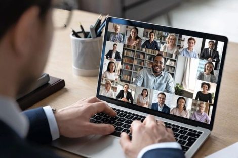 Businessman_talking_to_team_of_colleagues_on_online_video_conference_call_on_laptop._Screen_view_of_coach,_teacher_and_students_attending_webinar._Distance_business_meeting,_remote_work_concept