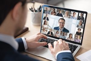 Rear_view_of_businessman_speak_on_web_conference_with_diverse_colleagues_using_laptop_Webcam,_male_employee_talk_on_video_call_with_multiracial_coworkers_have_online_meeting_briefing_from_home
